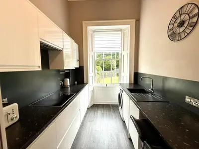 a kitchen with black counter tops and a window at New Town luxury 1 bed apartment in Edinburgh