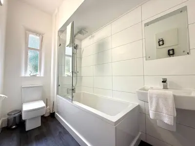 a white bathroom with a tub and a sink at New Town luxury 1 bed apartment in Edinburgh