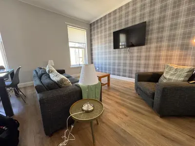 a living room with two couches and a tv at The Seaport Apartnment in Greenock