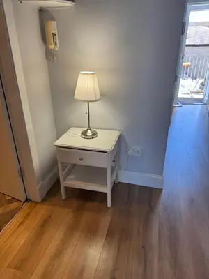 a lamp on a white table in a hallway at The Seaport Apartnment in Greenock