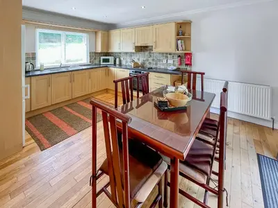 a kitchen with a wooden table and chairs in a room at Riverview Cottage in Kenmore