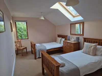 a bedroom with two beds and a skylight at Memorising sea views contemporary, spacious 4 bedroom coastal villa near Oban in Craobh Haven