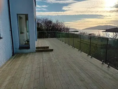 a balcony of a house with a view of the water at Memorising sea views contemporary, spacious 4 bedroom coastal villa near Oban in Craobh Haven