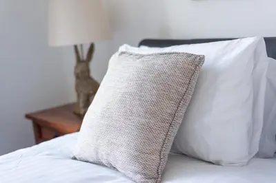 a pillow sitting on top of a bed with white pillows at Cosy 2-bedroom Edinburgh flat close to city centre in Edinburgh