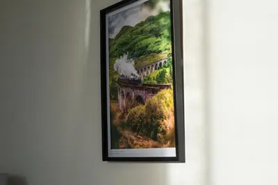 a framed painting of a train traveling over a bridge at Cosy 2-bedroom Edinburgh flat close to city centre in Edinburgh