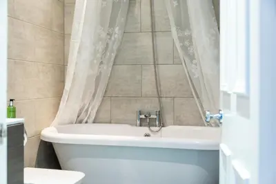 a bathroom with a tub and a toilet and a sink at Cosy 2-bedroom Edinburgh flat close to city centre in Edinburgh