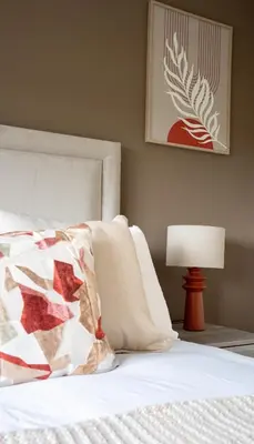 a bed with a pillow and a lamp next to it at Rise House in Livingston