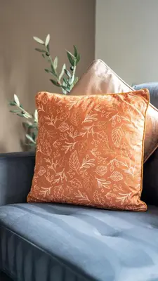 an orange pillow sitting on a blue couch at Rise House in Livingston