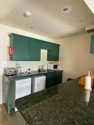 a kitchen with green cabinets and a counter top at Inveraray, Loch Awe Rooms and Apartments in Portsonachan