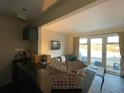 a living room with a wicker chair and a couch at Inveraray, Loch Awe Rooms and Apartments in Portsonachan