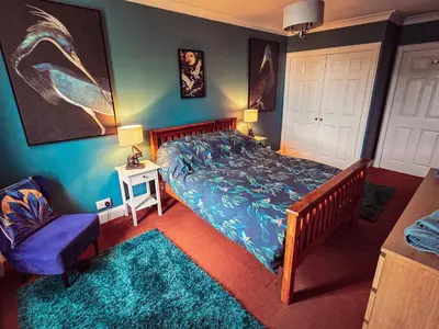 a bedroom with a bed with a blue comforter at 2 Bed Flat - Sleeps 4 - Pets - Parking - Wifi in Rothesay