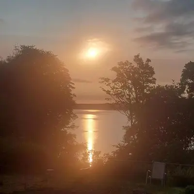 a sunset over a body of water with trees at 2 Bed Flat - Sleeps 4 - Pets - Parking - Wifi in Rothesay