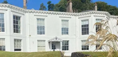 a large white house with trees in the background at 2 Bed Flat - Sleeps 4 - Pets - Parking - Wifi in Rothesay