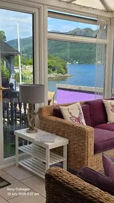 a living room with a couch and a table at Jenny's Bay with Hot Tub in Lochgoilhead