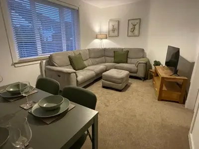 a living room with a couch and a table at West Highland Hideaway in Kinlochleven