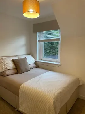 a bed in a bedroom with a window at West Highland Hideaway in Kinlochleven