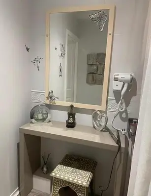 a bathroom with a mirror and a hair dryer at Relaxing 5-star farm stay sleeps 20 with spa! in Kirk of Shotts