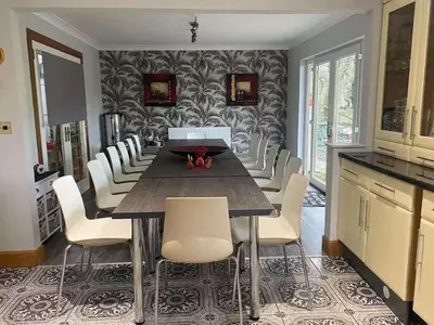 a dining room with a table and white chairs at Relaxing 5-star farm stay sleeps 20 with spa! in Kirk of Shotts