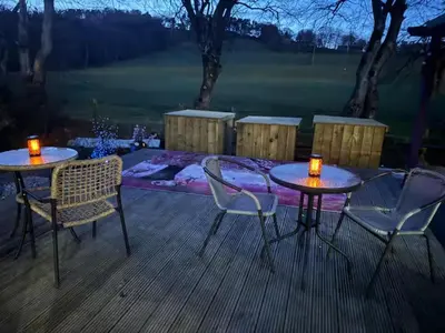 two tables and chairs on a deck with candles on them at Relaxing 5-star farm stay sleeps 20 with spa! in Kirk of Shotts