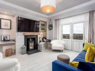 a living room with a blue couch and a fireplace at Sea view Villa Holiday and Corporate Let Accommodation in Prestwick