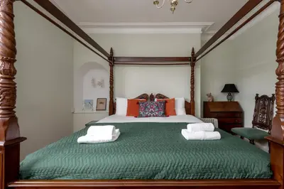 a bedroom with a green bed with towels on it at Double Edinburgh Homestay in Edinburgh