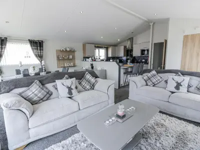 a living room with two couches and a table at Manor Heights Lodge in Wemyss Bay