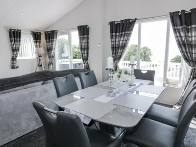 a dining room with a table and chairs at Manor Heights Lodge in Wemyss Bay