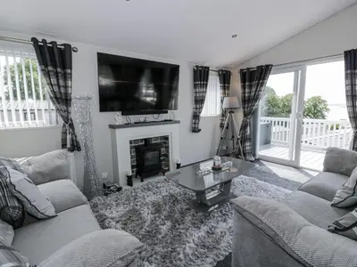 a living room with two couches and a fireplace at Manor Heights Lodge in Wemyss Bay