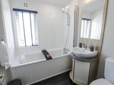 a bathroom with a tub and a sink and a bath tub at Manor Heights Lodge in Wemyss Bay
