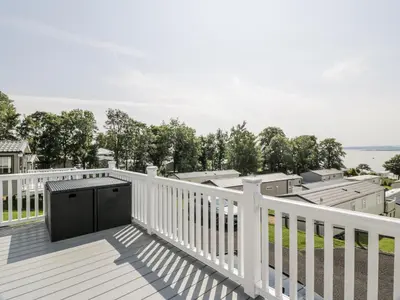 a balcony with a black door on a white fence at Manor Heights Lodge in Wemyss Bay