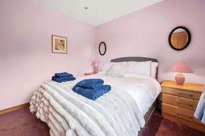 a bedroom with a bed with two blue towels on it at Spacious 4BD Home with Stunning Oban Views in Oban