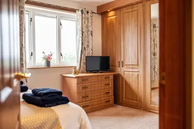 a bedroom with a bed and a television on a dresser at Spacious 4BD Home with Stunning Oban Views in Oban