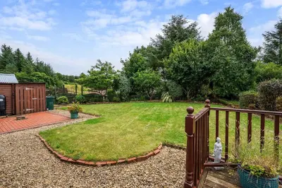 a garden with a wooden fence and a yard at Spacious 4BD Home with Stunning Oban Views in Oban