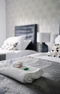 a hotel room with two beds with a towel and a lamp at 3 BDR House By Caledonia Luxe Stays Short Lets & Serviced Accommodation West Calder in West Calder