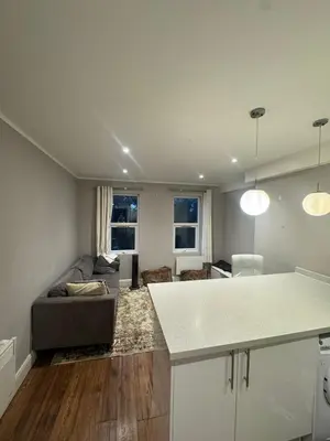 a kitchen and living room with a couch and a table at Amazing Flat in London in Moffat
