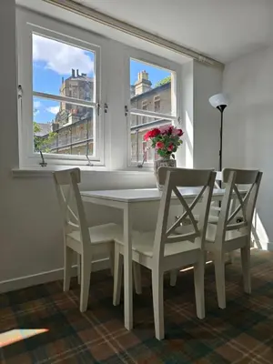 a dining room with a table and chairs and a window at Castle View Central Flat in Edinburgh