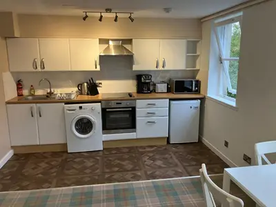 a kitchen with a washing machine and a sink at Castle View Central Flat in Edinburgh