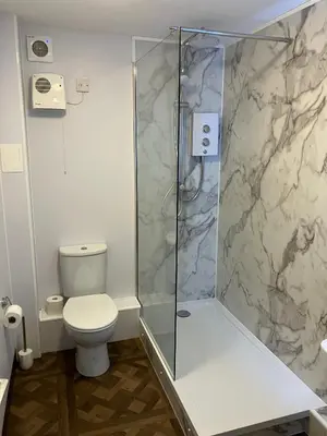 a bathroom with a toilet and a glass shower at Castle View Central Flat in Edinburgh