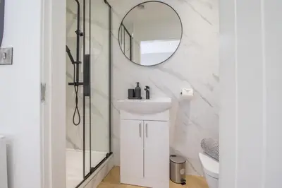 a bathroom with a sink and a mirror at Alexandra Apartment in Falkirk