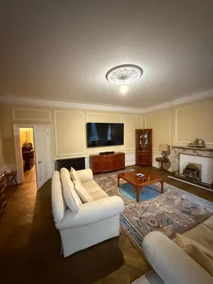 a living room with a white couch and a tv at Entire rental in Edinburgh City Centre in Edinburgh