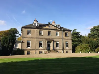 an old house with a large grass field in front at Limefield Mansion House in Livingston