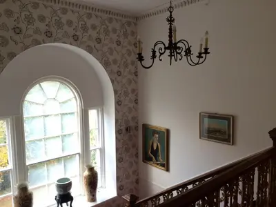 a staircase with a window and a chandelier at Limefield Mansion House in Livingston