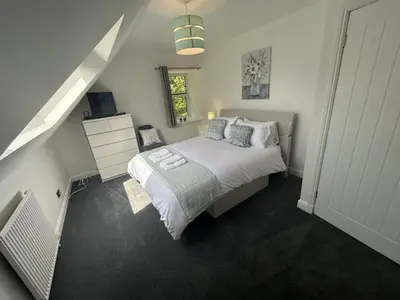 a bedroom with a large bed and a staircase at The Stables in Symington in Symington