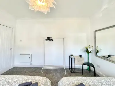 a white room with a mirror and a table at New quite and comfy home Glasgow in Knightswood