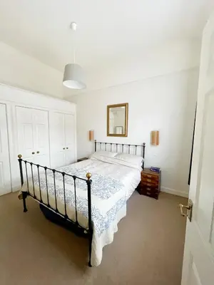 a bedroom with a black bed with a white comforter at Little West End cottage in Edinburgh