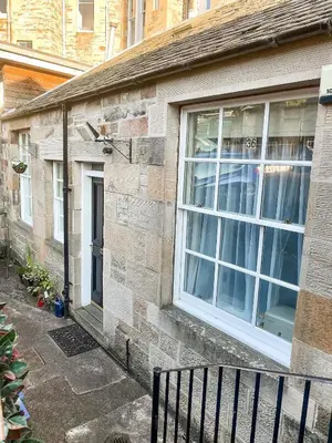 a brick house with a window and a bench at Little West End cottage in Edinburgh