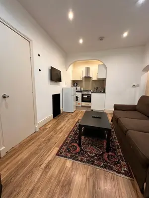 a living room with a couch and a table at Caledonian Apartment in Edinburgh