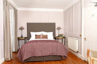 a bedroom with a bed and two tables with lamps at Blossom Mansion in Edinburgh