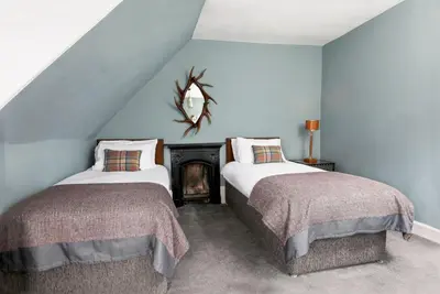 two beds in a room with blue walls at Blossom Mansion in Edinburgh