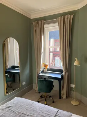 a bedroom with a desk and a window with a mirror at Townhead Jewel by Coorie Doon Stays in Paisley